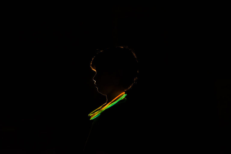 A backlit portrait of a boy with glow necklaces | Washington DC child photographer | 10th birthday interview
